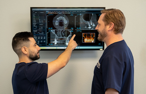 Two oral surgeons looking at an x-ray of a patient's jaw
