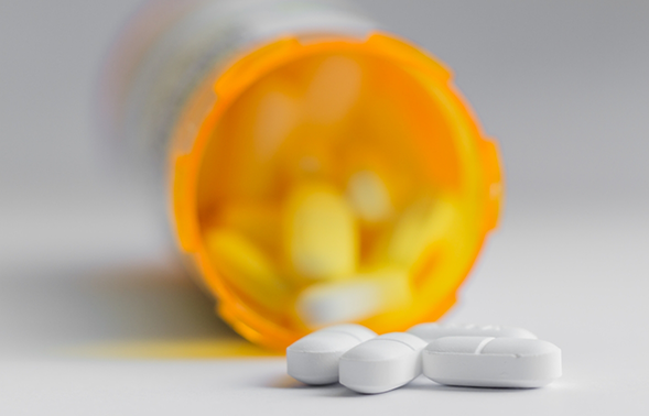 Orange bottle filled with white pills