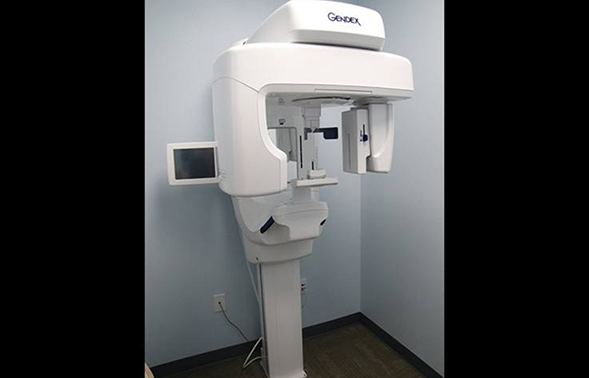 Cone beam CT scanner standing against a wall