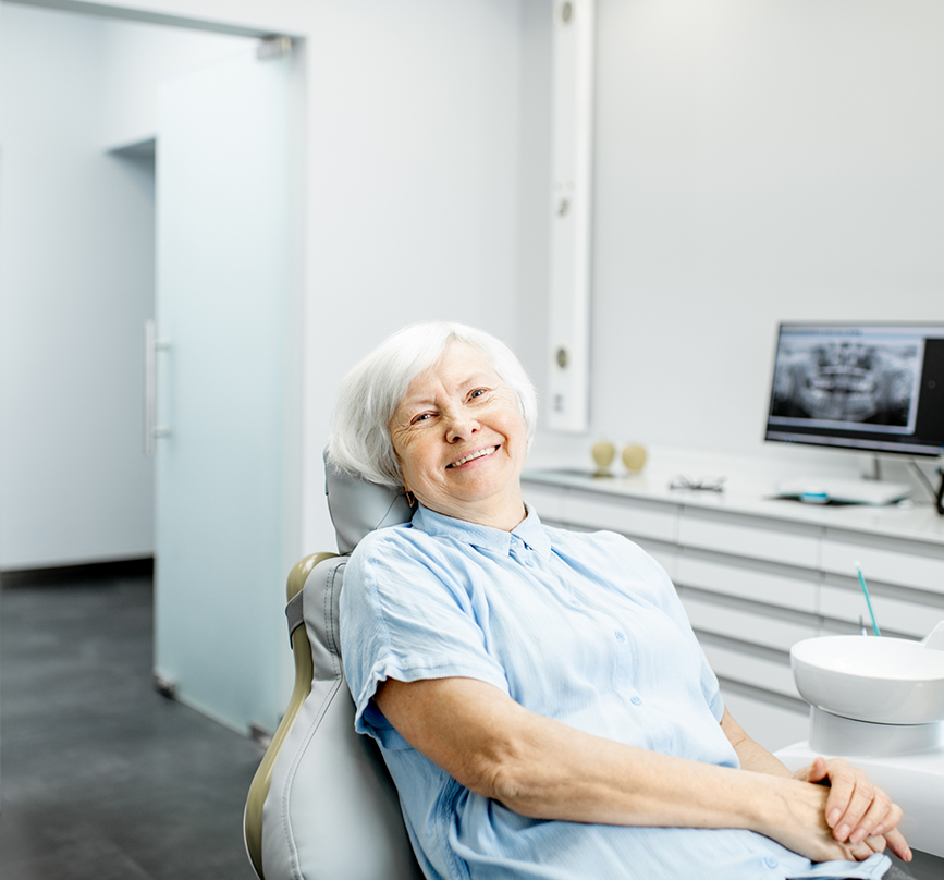 Senior woman in the dental chair smiling with All-on-X dental implants in Prosper