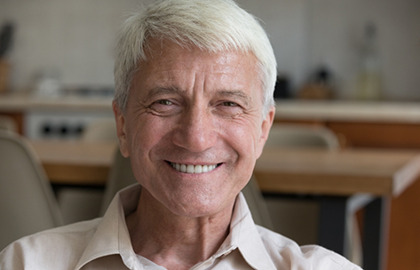 Senior man grinning in a collared shirt