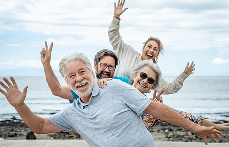 Four adults smiling on a beach