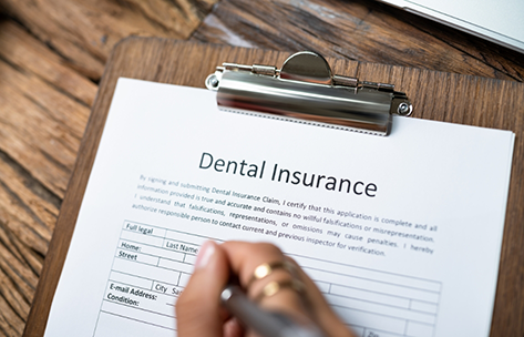 Person filling out dental insurance paperwork