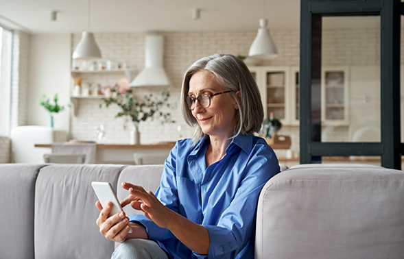Woman sitting on a couch and typing on her phone