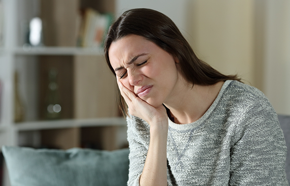 Woman holding the side of her jaw in pain