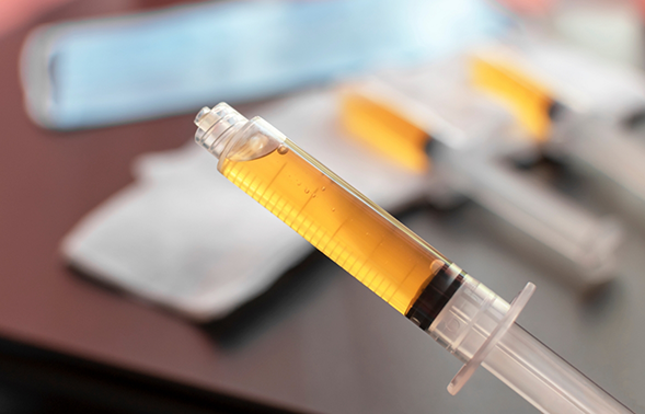 Syringe of a yellowish brown liquid