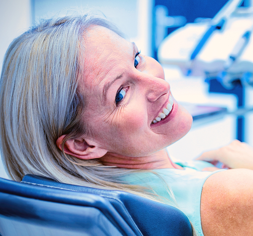 Woman smiling in the treatment chair after gum grafting in Prosper