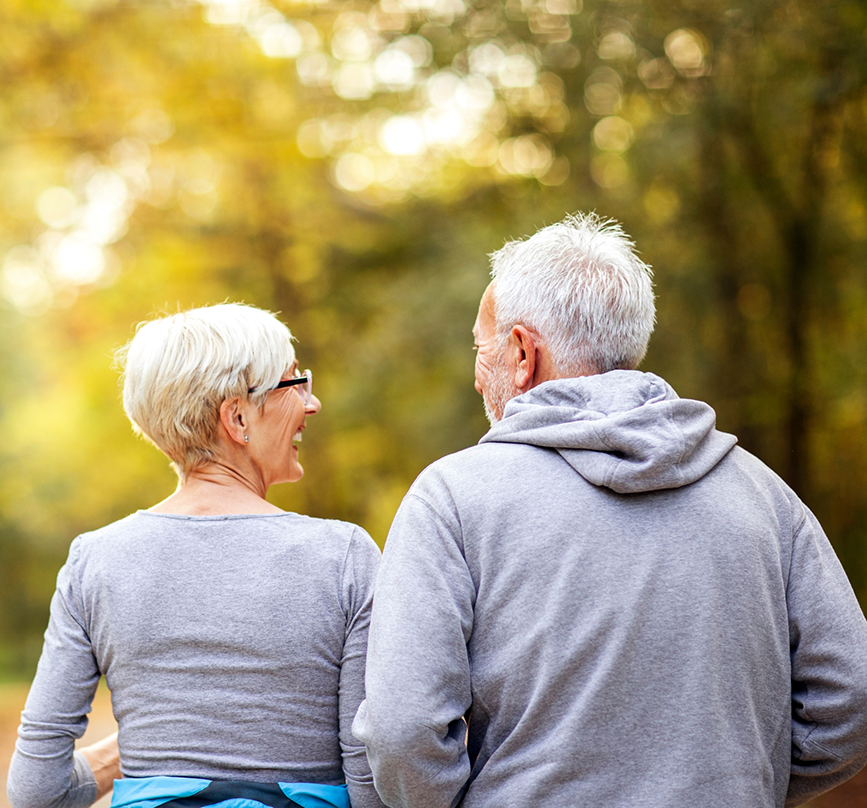Senior couple with implant dentures walking outdoors