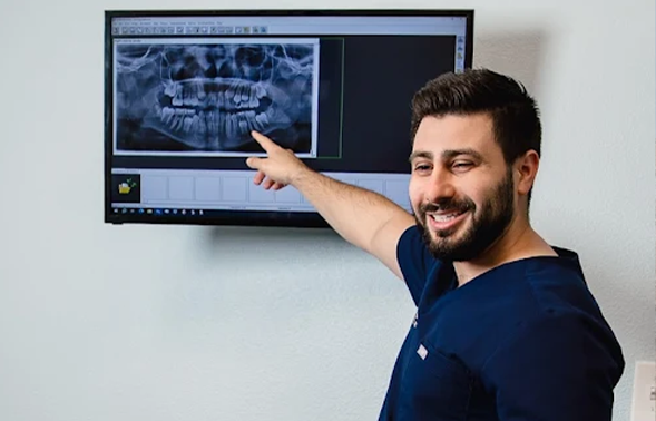 Doctor Houari showing a patient an x-ray of their teeth