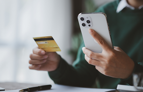 Person holding their phone and their credit card