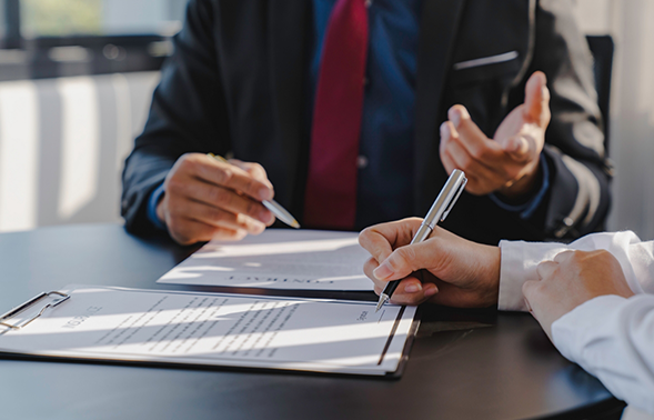Two people at a desk filling out paperwork