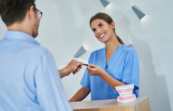 Man paying for his dental treatment