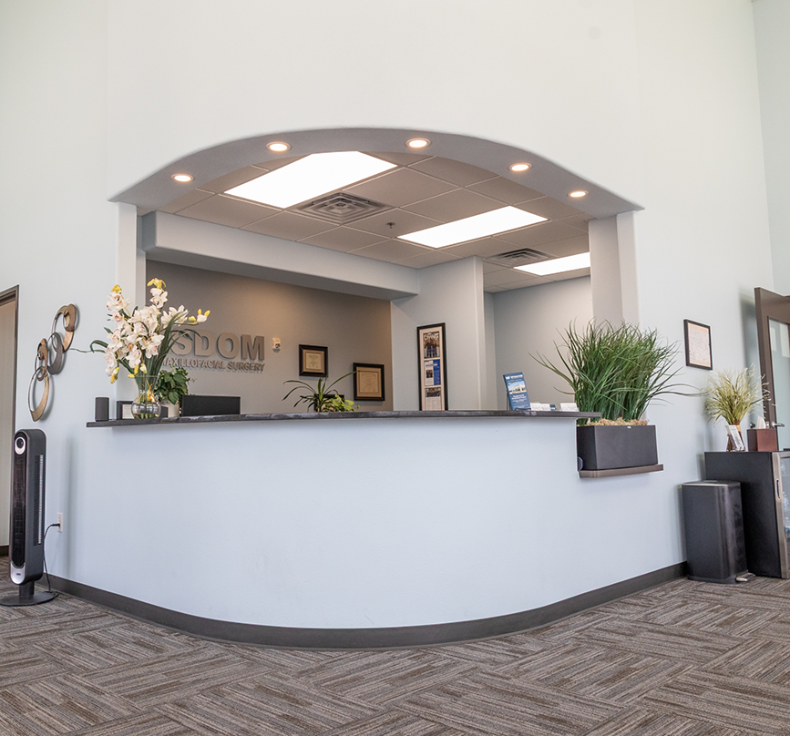 Smiling woman in the treatment chair listening to her oral surgeon in Prosper