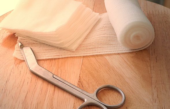 Scissors next to a roll of gauze